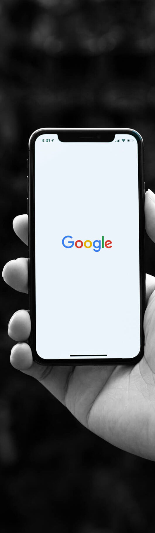 Mobil i hånd viser hjemmesiden til Google.